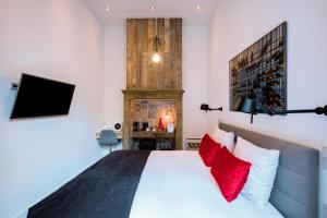 a bedroom with a white bed with red pillows at Boutique Hotel ZIES in Utrecht