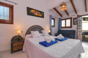 a bedroom with a bed with blue towels on it at Casa Virginia in Jávea