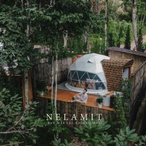 清邁的住宿－Nelamit เนรมิต，坐在帐篷旁甲板上的男人