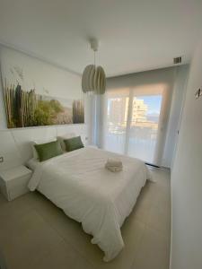 een witte slaapkamer met een groot bed en een raam bij Infinity View SNB in Arenales del Sol