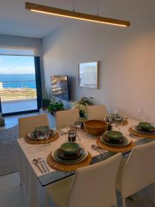een eetkamer met een tafel en stoelen en de oceaan bij Infinity View SNB in Arenales del Sol