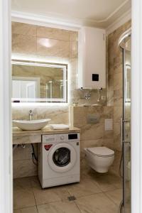 ein Badezimmer mit einer Waschmaschine und einem Waschbecken in der Unterkunft Sun apartments in Kiew