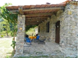een stenen huis met 2 stoelen en een tafel bij Casa Gruppetta in Tortorella