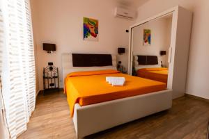 sypialnia z 2 łóżkami i dużym lustrem w obiekcie Appartamenti Vittoria w Syrakuzach