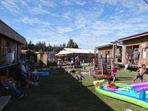 um grupo de pessoas jogando em tubos infláveis na grama em Surf and Stay Chile em Navidad