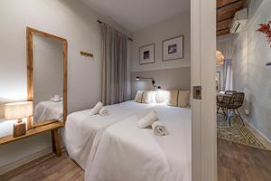 a hotel room with two beds and a mirror at Habitat Apartments Sweet Sagrada Familia in Barcelona