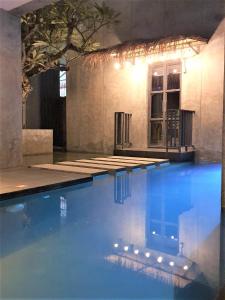 喬木提恩海灘的住宿－Villa by the Win Pattaya，蓝色海水游泳池和大楼