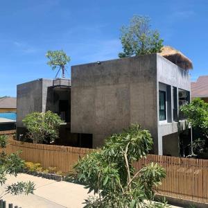 a concrete house with a fence in front of it at Villa by the Win Pattaya in Jomtien Beach