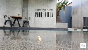 a pool with a sign that reads a not quite private pool villa at Villa by the Win Pattaya in Jomtien Beach