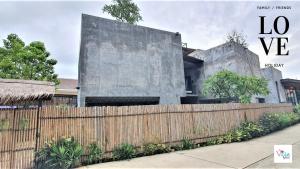 a building with a wooden fence in front of it at Villa by the Win Pattaya in Jomtien Beach