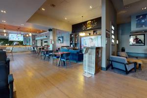 a restaurant with tables and chairs and a bar at Village Hotel Leeds South in Leeds