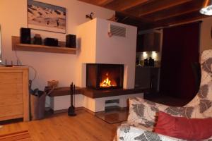 a living room with a fireplace and a couch at Feriendorf Via Claudia Haus 59 Gamsbock in Lechbruck
