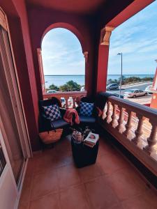 a balcony with chairs and a view of the ocean at APARTAMENTO FRENTE AL MAR CON PRECIOSAS VISTAS in Mazagón