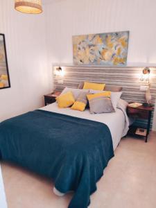 a bedroom with a large bed with yellow pillows at APARTAMENTO FRENTE AL MAR CON PRECIOSAS VISTAS in Mazagón