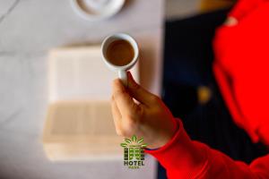 a person is holding a cup of coffee at Hotel Park in Prishtinë