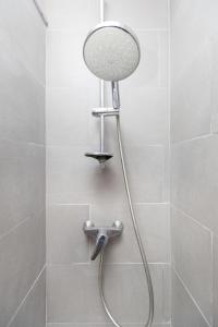 a shower with a shower head in a bathroom at Cathedral Apartments in Barcelona
