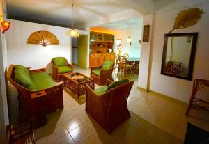 un soggiorno con sedie verdi e specchio di Lovely 2-bedroom condo close to the beach… a Trou aux Biches Altre 2 foto