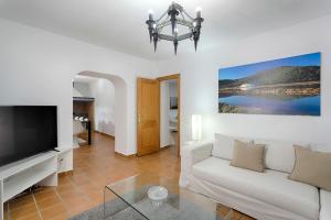 a living room with a white couch and a tv at Villa Simona Ibiza in Ibiza Town