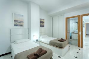 1 dormitorio con 2 camas y toallas. en Villa Simona Ibiza en Ibiza