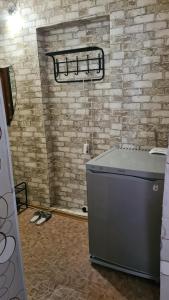 eine Waschmaschine in einem Zimmer mit Ziegelwand in der Unterkunft 1 комнатная квартира в центре in Oral