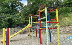 une aire de jeux colorée avec toboggan dans un parc dans l'établissement Camping Lac de Villefort, à Villefort