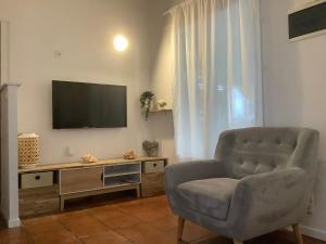 a living room with a chair and a television at VILLA ALIZEE APPARTEMENT N°6 in Sainte-Rose
