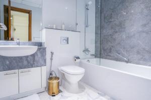 a bathroom with a sink and a toilet and a bath tub at Primestay - Meera Tower 2BR in Habtoor City in Dubai