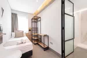 a bedroom with two beds and a glass wall at Hotel La Milagrosa in Alicante
