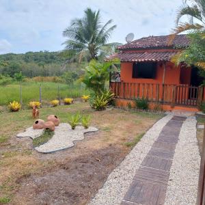 Casa temporada jaguaripe bahia toca do guaiamum في Jaguaripe: منزل مع حديقة مع دمية الدب على الأرض