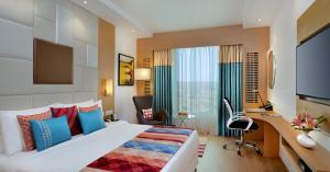 a hotel room with a large bed and a desk at Fortune Inn Promenade, Vadodara - Member ITC's Hotel Group in Vadodara