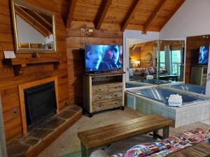 a living room with a tub and a tv and a fireplace at Foxy Lady #1531 in Gatlinburg