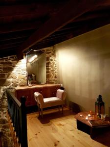 Zimmer mit einem Spiegel, einem Stuhl und einem Tisch in der Unterkunft Chios Houses, beautiful restored traditional stone houses with an astonishing seaview in Volissos