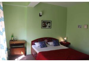um quarto com uma cama numa sala verde em Dazzle Homestay em Gangtok