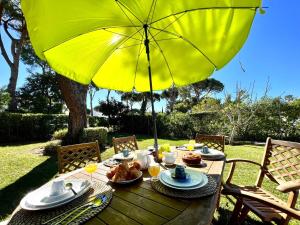 un tavolo con un ombrello giallo e del cibo sopra di Vilamoura Ocean Villa with Pool by Homing a Vilamoura
