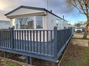 a tiny house with a blue fence at 7 Lakes Breaks at 7 Lakes Country Park in Crowle