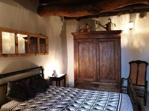 Schlafzimmer mit einem Bett und einem Holzschrank in der Unterkunft Chios Houses, beautiful restored traditional stone houses with an astonishing seaview in Volissos