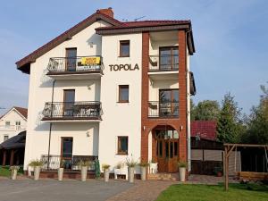 a tall white building with a sign on it at TOPOLA in Gąski