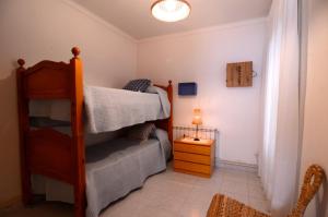 een slaapkamer met een stapelbed en een nachtkastje bij Enric Serra 54 in L'Escala