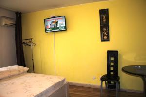 a bedroom with a yellow wall with a bed and a television at Premium family apartment, Floreasca area in Bucharest