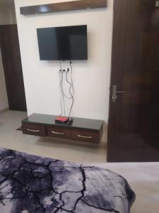 einen TV an der Wand in einem Zimmer mit einem Bett in der Unterkunft Hotel Uday Raj By WB Inn in Agra