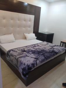 a bedroom with a large bed with a large headboard at Hotel Uday Raj By WB Inn in Agra