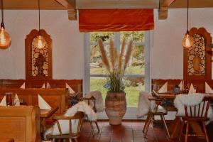 a restaurant with tables and chairs and a large window at Hotel Zum Forst in Kranzberg