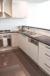 a kitchen with white cabinets and a sink at Bendigo Townhouse - Walk to the CBD in Bendigo