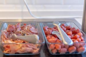 two plastic containers of food with fruit in a refrigerator at Hotel La Milagrosa in Alicante