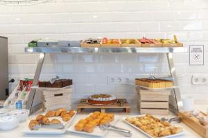 a bakery with various types of pastries on a shelf at Hotel La Milagrosa in Alicante