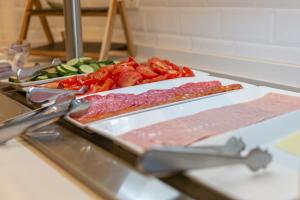 a bunch of meat and vegetables on a counter at Hotel La Milagrosa in Alicante