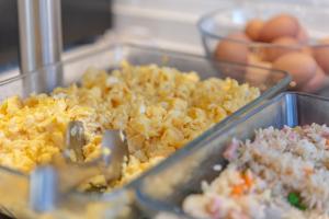 a tray of food with rice and eggs on a table at Hotel La Milagrosa in Alicante
