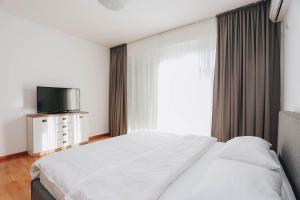 une chambre avec un lit, une télévision et une fenêtre dans l'établissement Status-M Apartments Sunny Side, à Becici