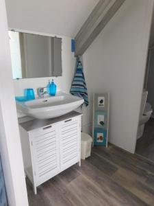 a bathroom with a white sink and a toilet at MAISON MER LA NOE in Saint-Cast-le-Guildo