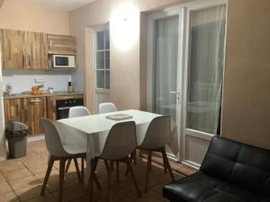a kitchen and dining room with a white table and chairs at VILLA ALIZÉE Logement 3 in Sainte-Rose